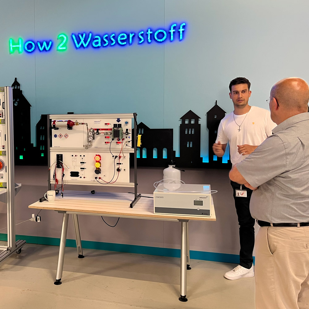 hcatplus-Wasserstoffdialog Zwei Menschen im Gespräch am Messestand Wasserstoffdialog