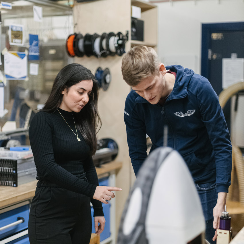 hcatplus_MAchmalTech Eine Frau und ein Mnn stehen in einer Werkstatt und besprechen ein Elektronikprojekt.